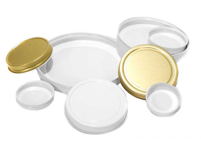 An assortment of white, metal, and gold caps for jars and bottles, in various sizes.