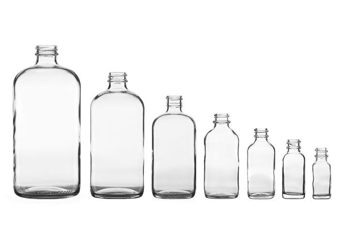 Seven glass bottles without caps in descending sizes from left to right.